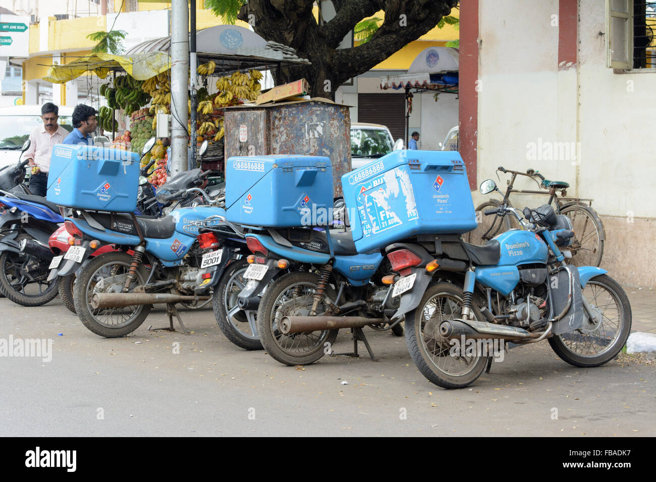 Dominos Pizza Motorräder geparkt neben einem traditionellen frisches Obst stehen in Panaji (Panjim), Nord-Goa, Indien Stockfoto