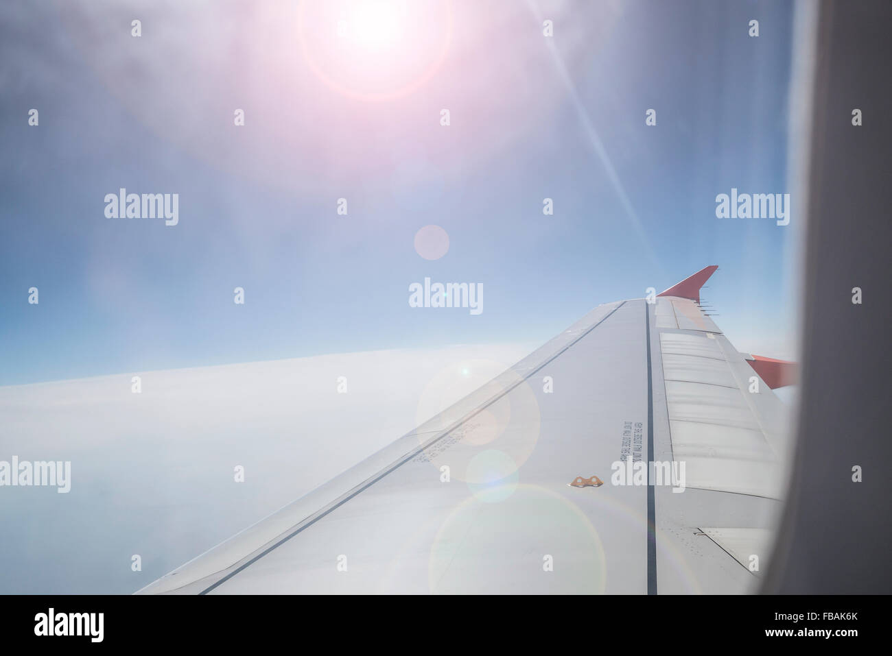 Blick vom Flugzeugfenster mit Blick in die Sonne Stockfoto