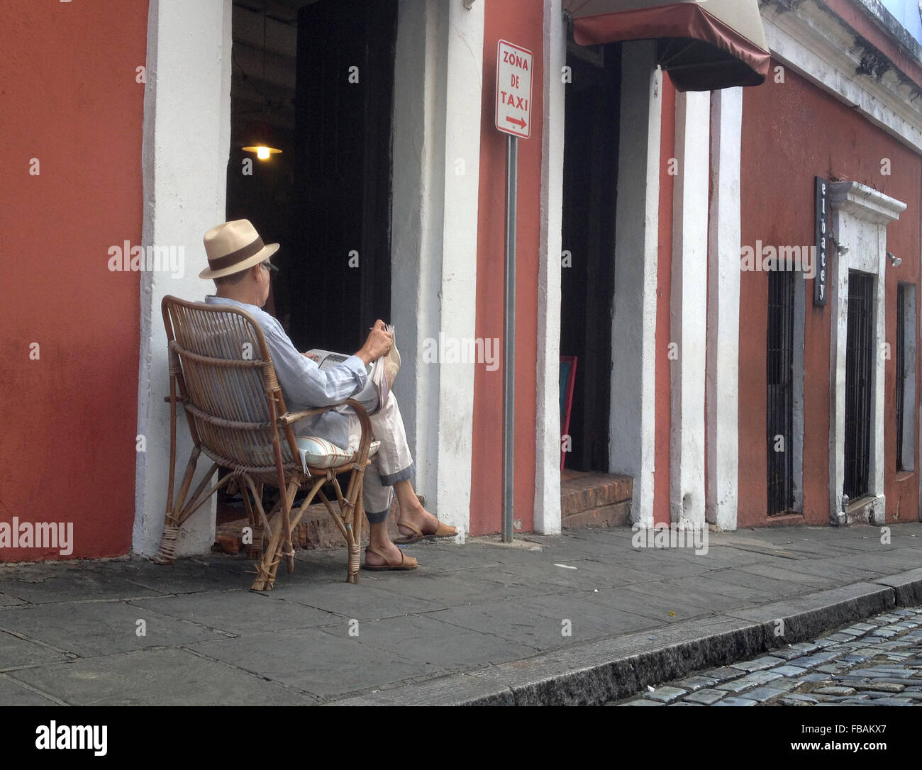 Ein Alter Mann liest eine Zeitung in Old San Juan, Puerto Rico. Stockfoto