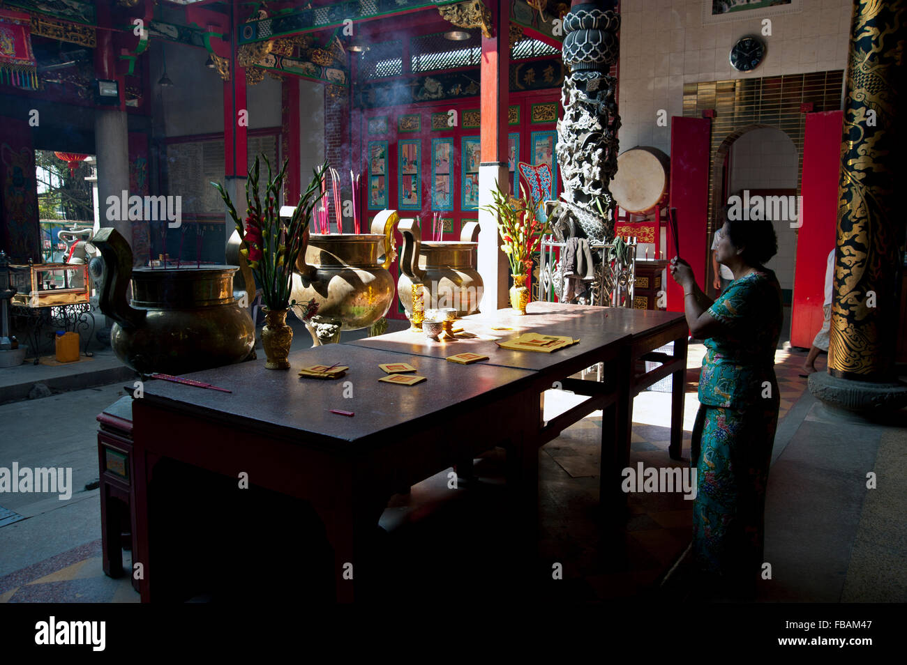 Chinesische Gläubige beten in den stimmungsvollen Schatten auf dem Altar eines chinesischen Tempels in Yangon Myanmar Stockfoto
