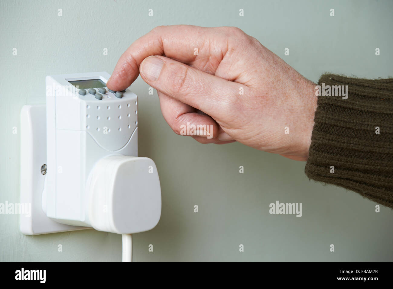 Nahaufnahme von Hand einstellen Zeitschaltuhr In Steckdose Stockfoto