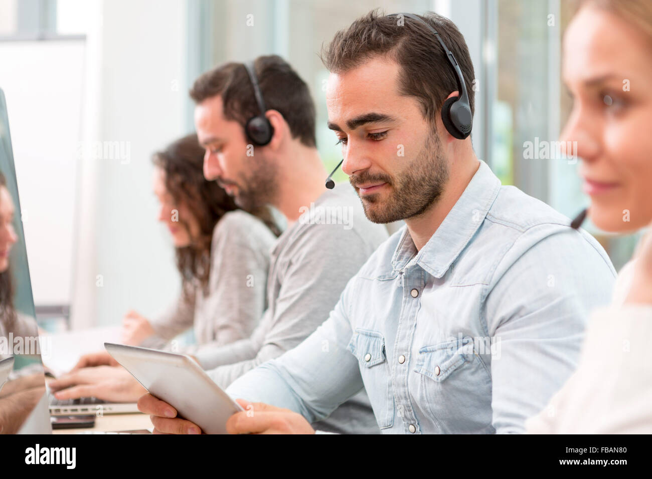 Blick auf einen jungen attraktiven Mann arbeitet in einem Callcenter Stockfoto
