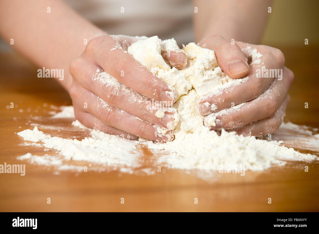Schließen Sie Hausmannskost, weibliche Hände kneten Paste auf Holztisch Stockfoto Schließen Sie Hausmannskost, weibliche Hände kneten Paste auf Holztisch Stockfoto