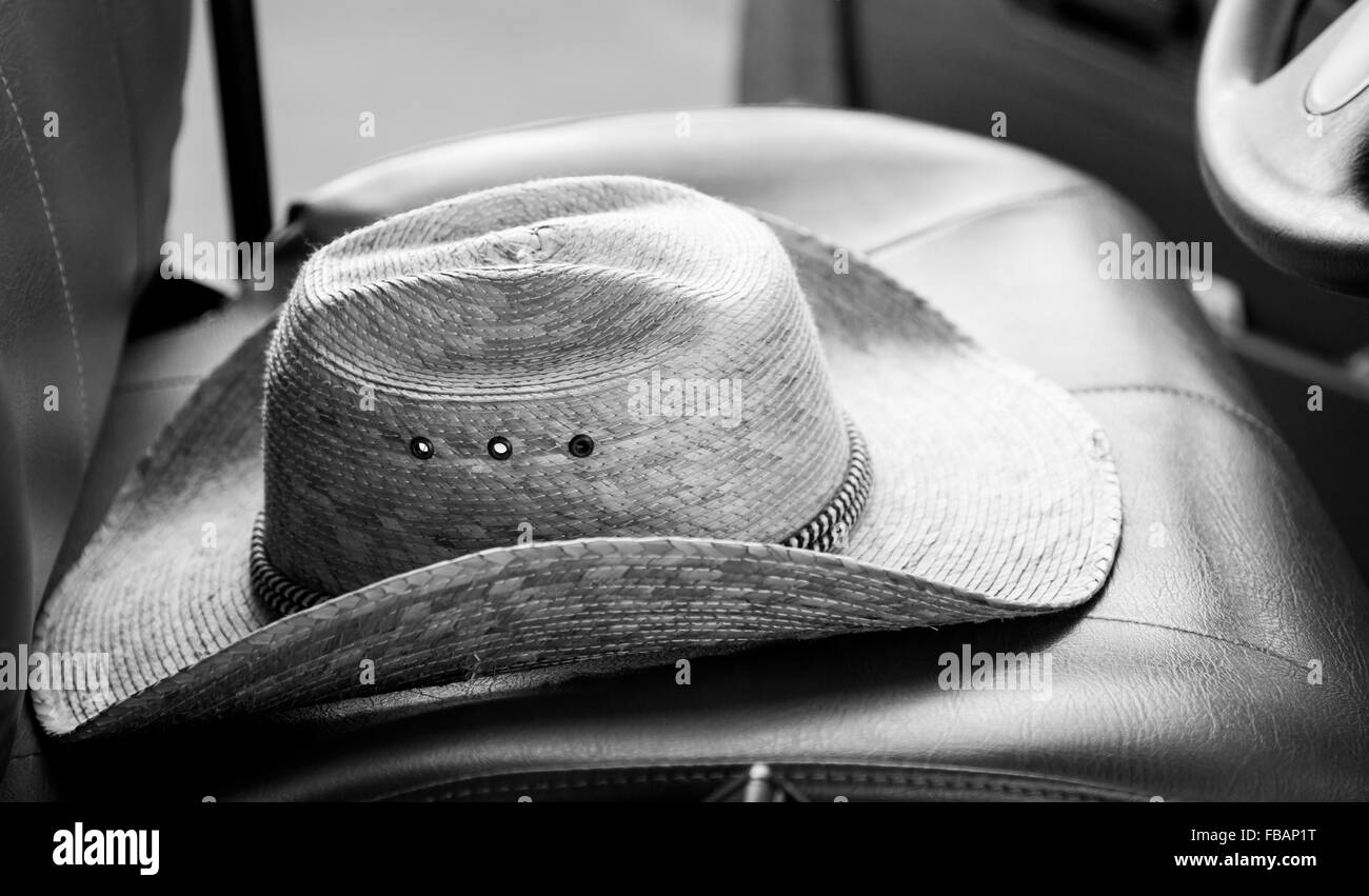 Strohhut auf einem LKW Fahrersitz, kurz geschoren und schwarz. Stockfoto