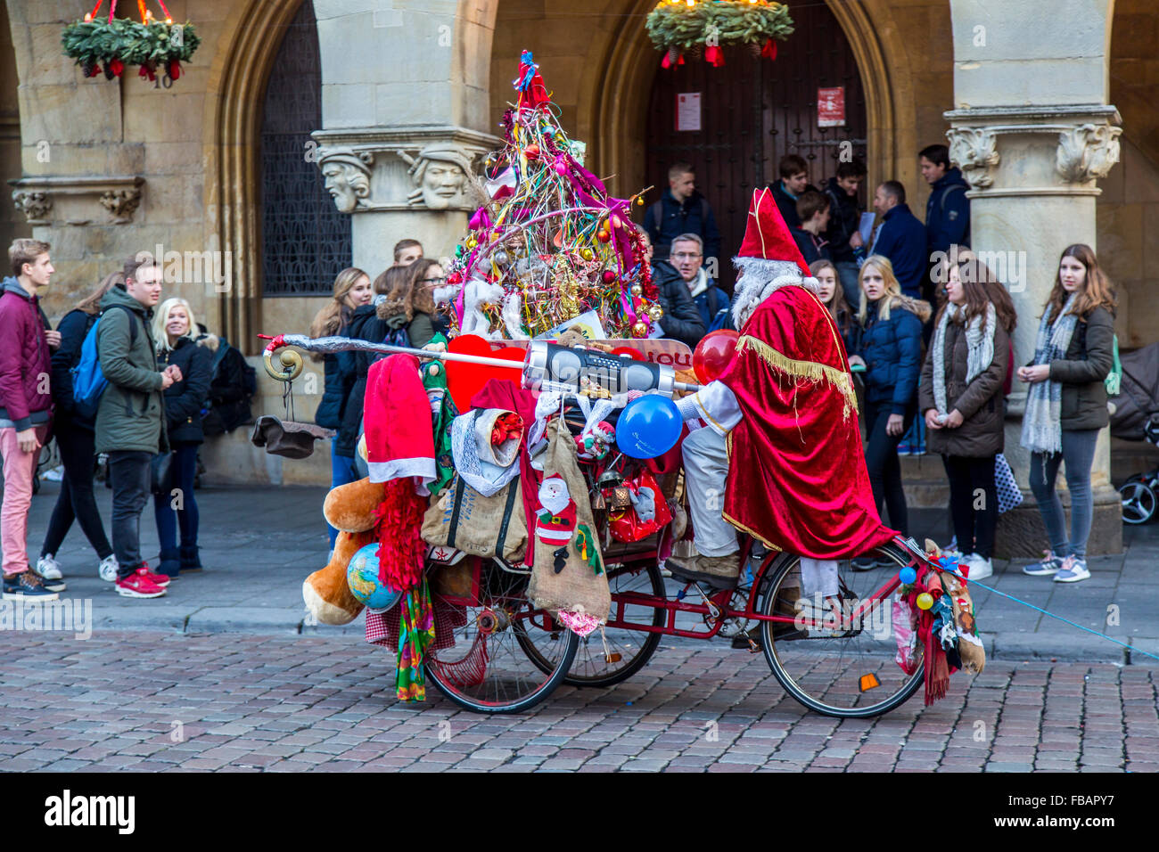 Streetart-Künstler im Weihnachtsmann-Kostüm, auf einem Fahrrad, Weihnachtszeit, Stadt Zentrum Münster, Deutschland Stockfoto