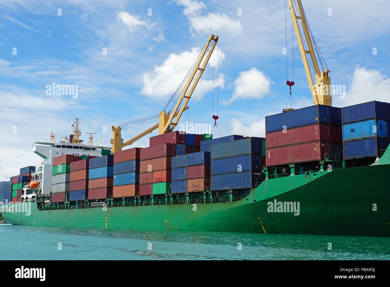 große grüne Containerschiff im Hafen von tropischen Stockfoto