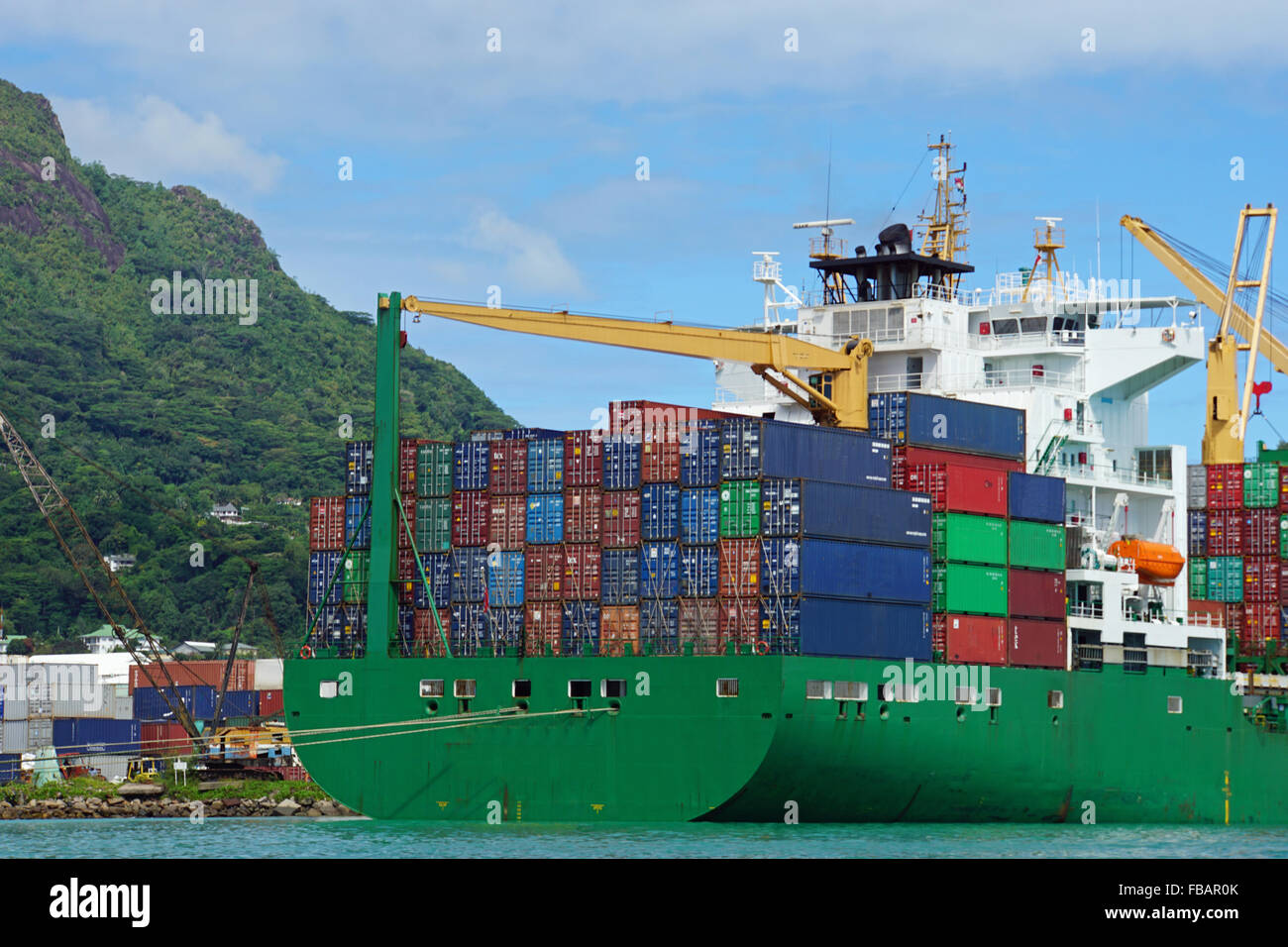 große grüne Containerschiff im Hafen von tropischen Stockfoto