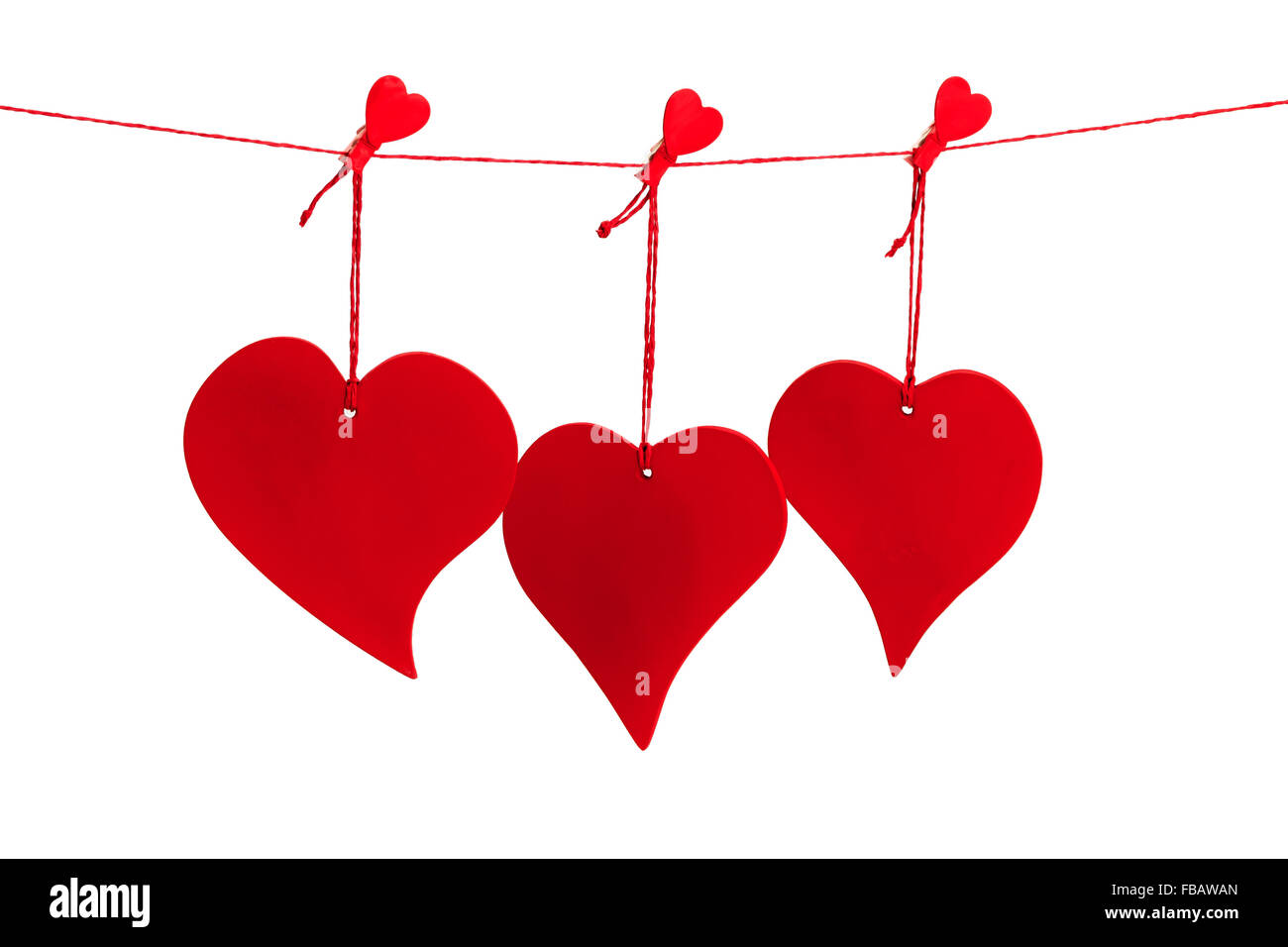 Drei rote Valentine Herzen hängen von einer roten Schnur isoliert auf weißem Hintergrund Stockfoto