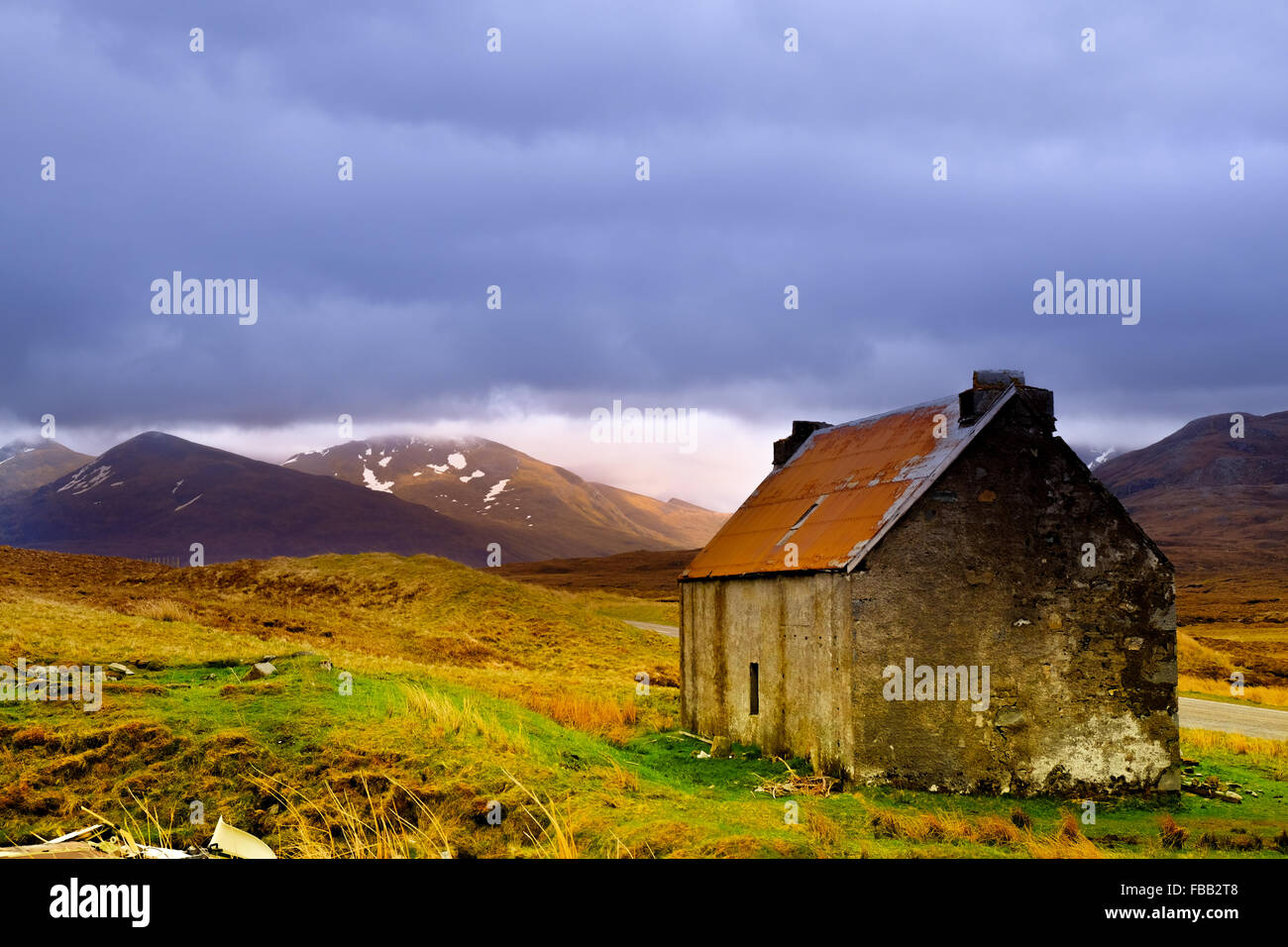 Ein Kredit-Croft-Haus in der Nähe der Westküste von Schottland in den Highlands steht für sich allein unter einem dunklen Himmel bedrohlich. Stockfoto