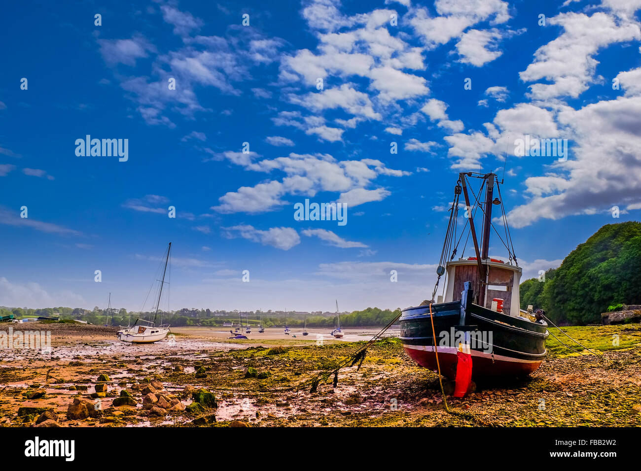 Ein Segelboot ruht auf den Rumpf bei Ebbe in Red Wharf Bay, Anglesey, Wales. Stockfoto