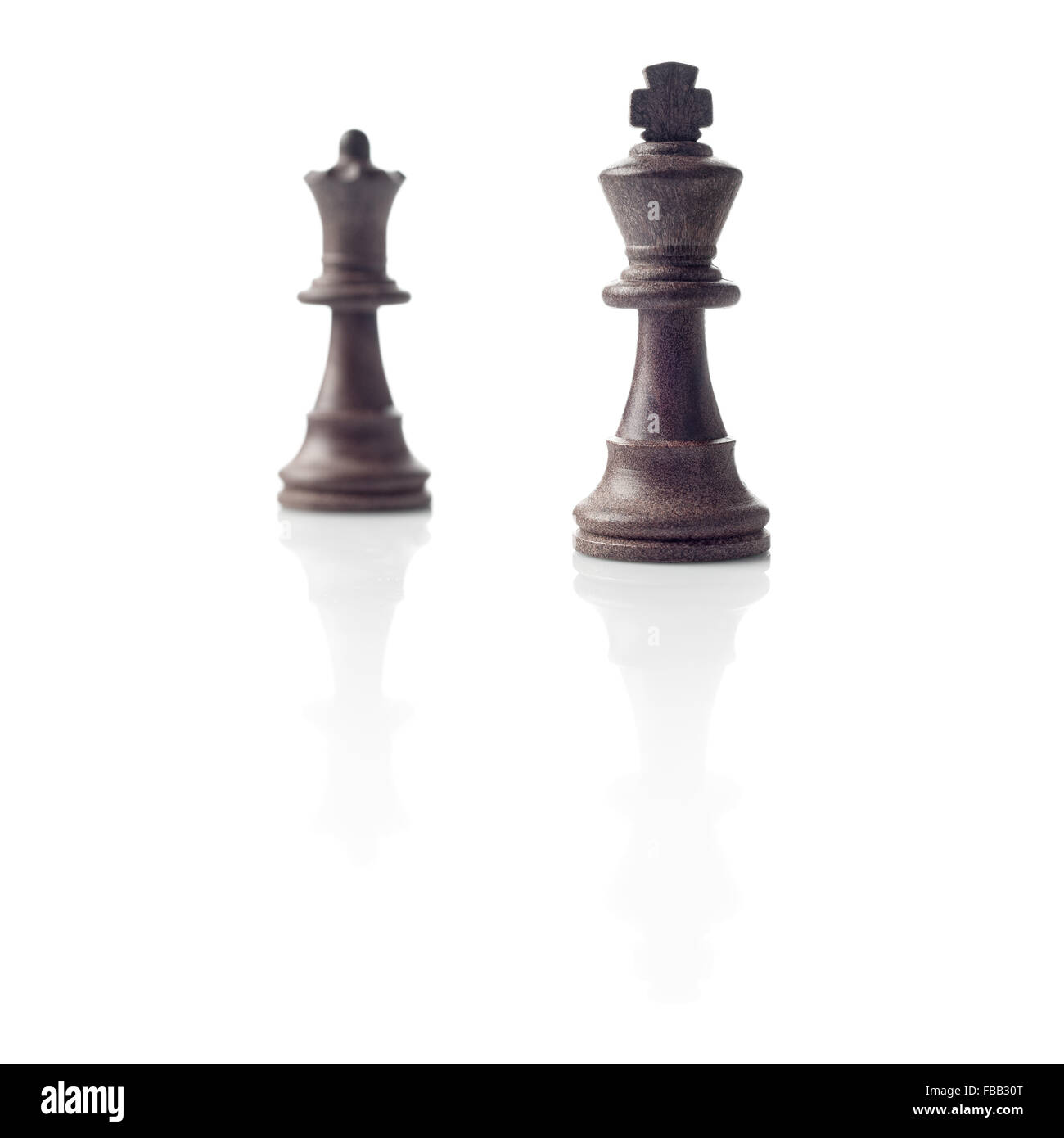 Schach. Schwarzer König und die Königin unscharf und ihre Schatten Reflexion auf weißem Hintergrund. Sieger, Leistung, Wettbewerb oder Führer Stockfoto