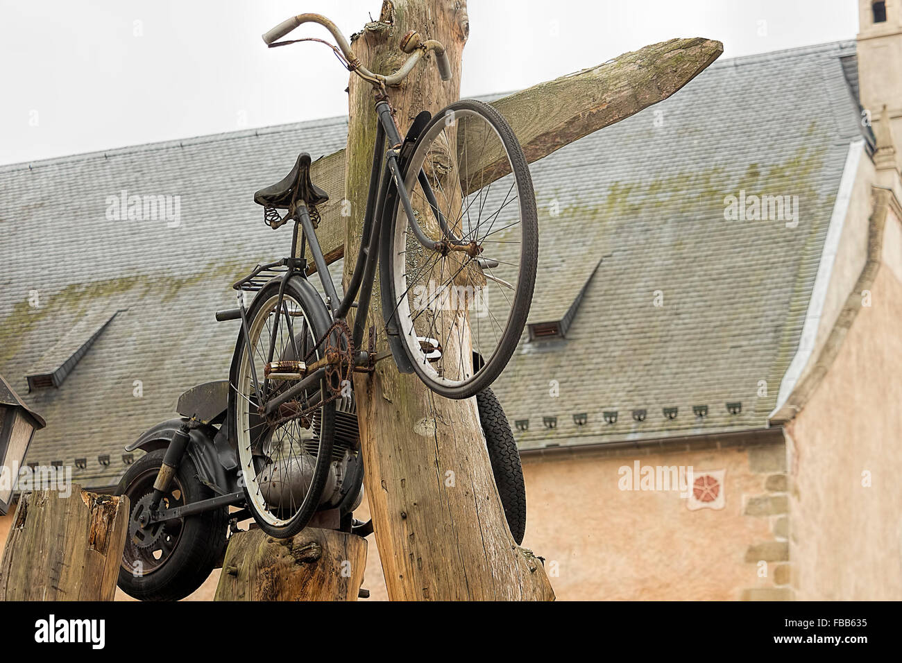 Alt und Grunge-Fahrrad und Motorrad auf alten Bauernhof an alten Holzpfahl aufgehängt. Stockfoto