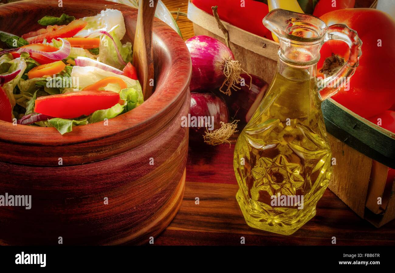 Essen Sie Gemüse. Frisch gemischter Haus-Salat mit frischen Zutaten und einer Glaskaraffe Dressing. Stockfoto