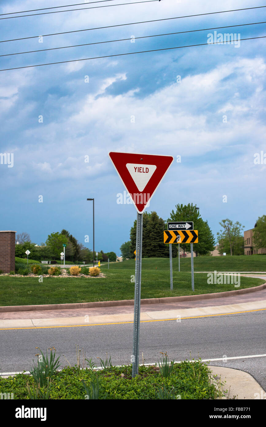 Rendite-Zeichen in der Nähe einen Kreisverkehr vor einem wolkigen Himmel Stockfoto