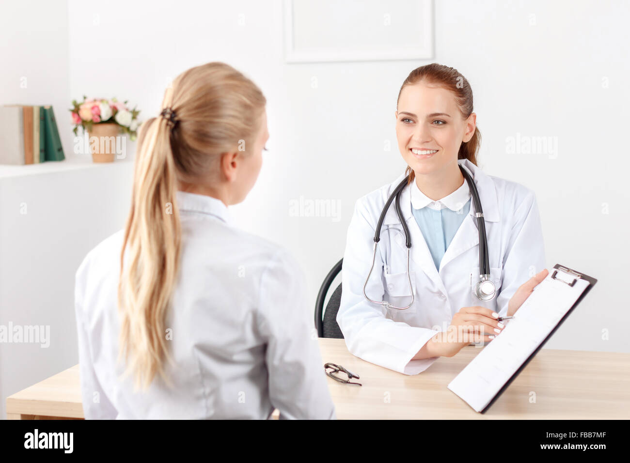 Lächelnde Kardiologe im Gespräch mit dem Patienten Stockfoto