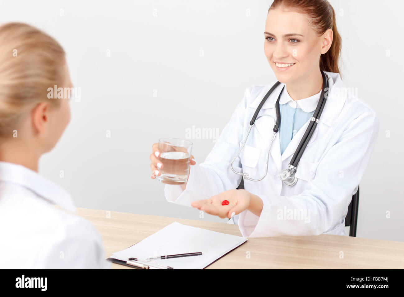Lächelnde Kardiologe im Gespräch mit dem Patienten Stockfoto