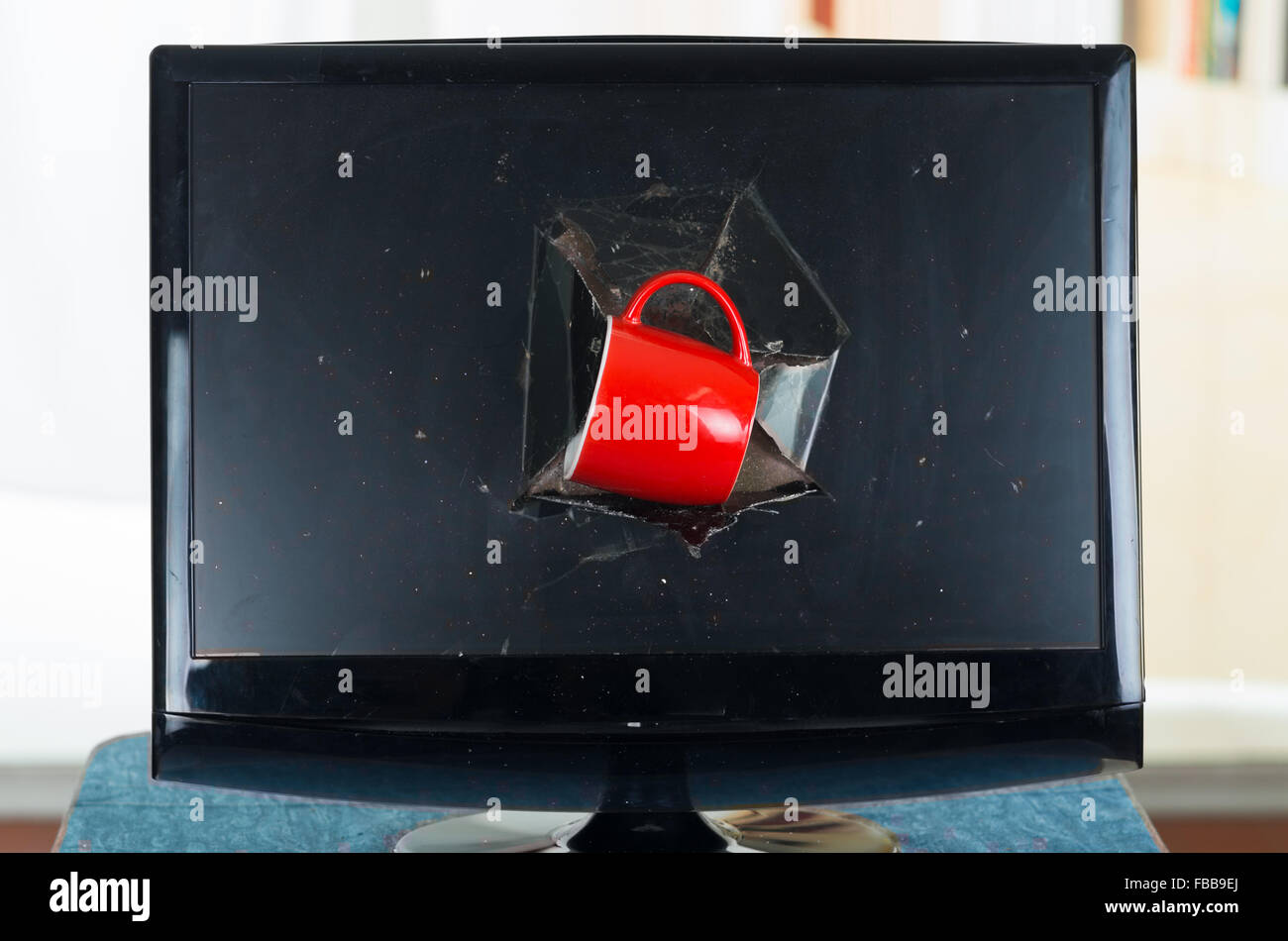 Rote Kaffeetasse in schwarz defekten Computerbildschirm stecken. Stockfoto