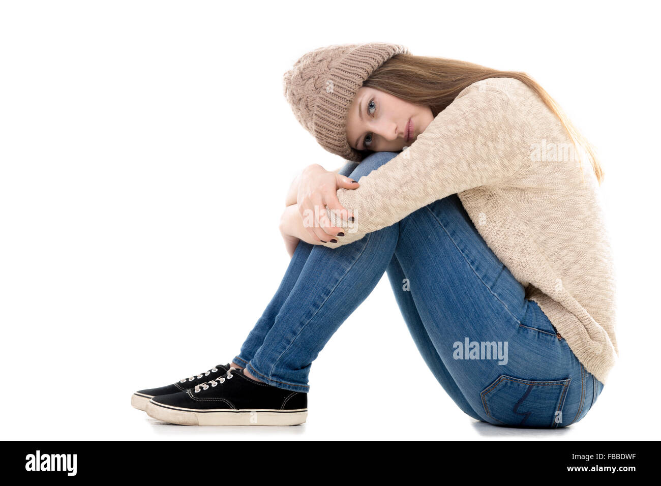 Traurige Teenager-Mädchen mit Problemen mit dem Kopf auf den Knien, Textfreiraum sitzen Stockfoto