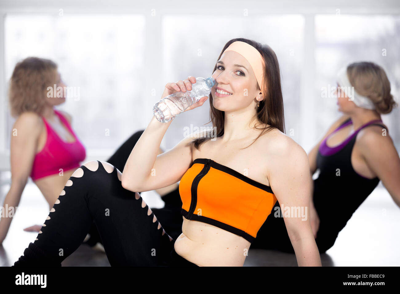 Schöne Mädchen mit Flasche Wasser nach dem Sport Training im Fitness-Klasse, Menschen entspannen, Ausruhen im Chat auf die Zeitmessung Stockfoto