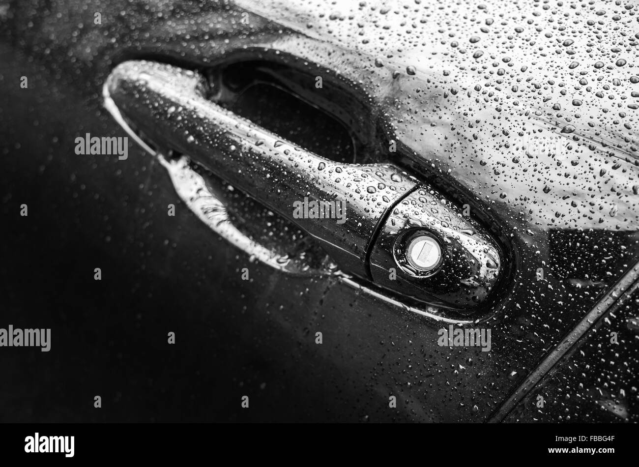 Schwarz glänzende Autos, Nahaufnahme Foto von nassen Fahrertür Griff mit Schlüsselloch. Tiefenschärfe und flachen DOF Stockfoto