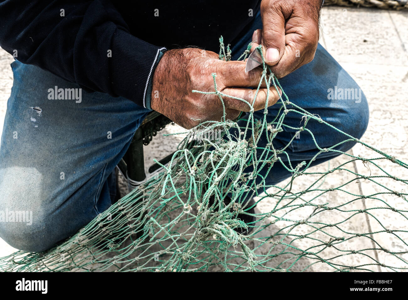 Fischer flickt die Netze an den Hafen von Mola di Bari Stockfoto