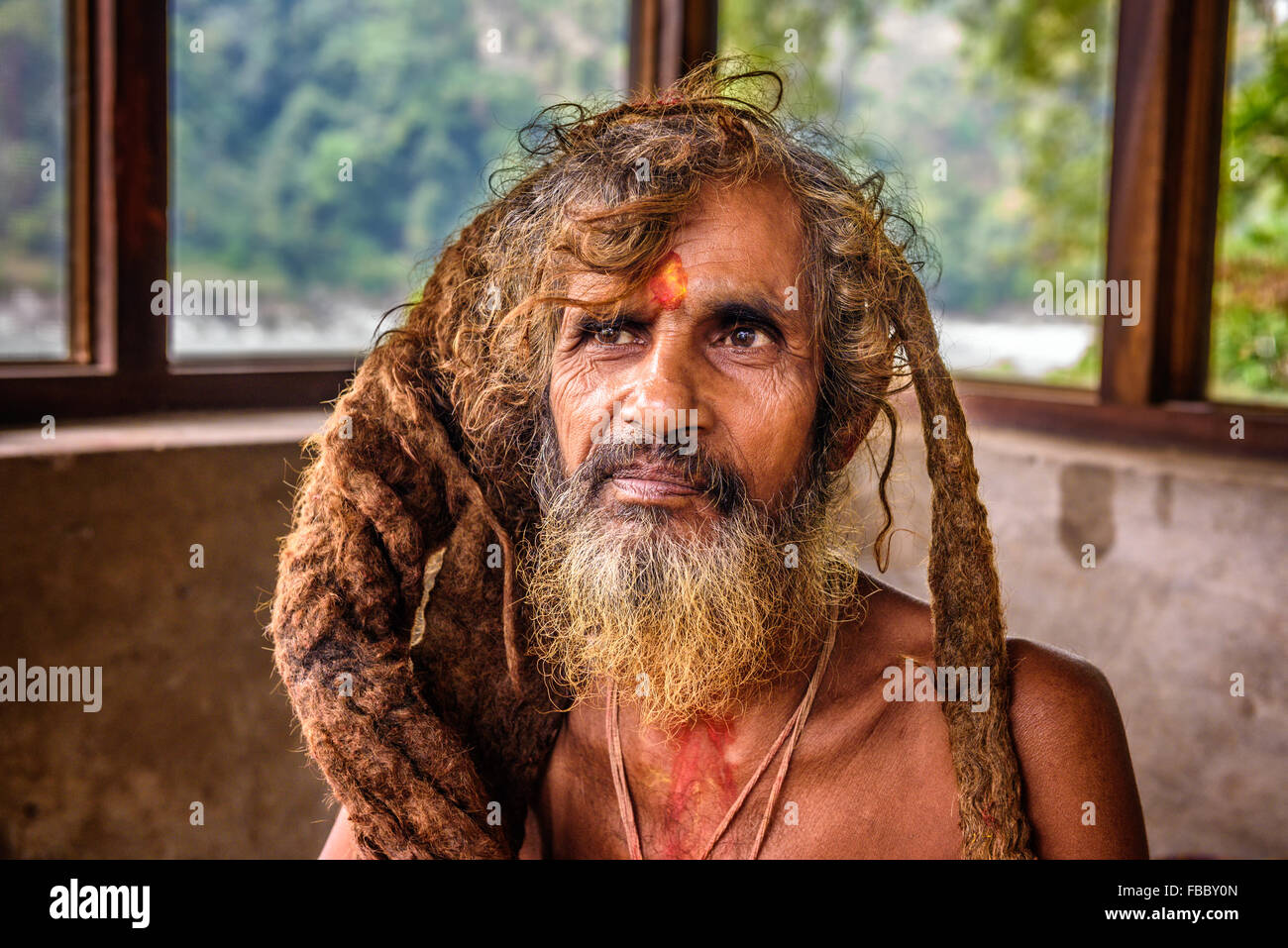 Porträt von einem Sadhu Baba (Heiliger) mit traditionellen langen Haaren in einem nepalesischen Tempel Stockfoto