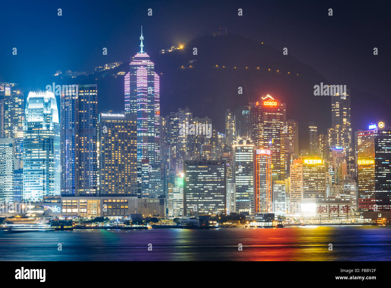 Die Skyline von Hong Kong und Victoria Peak in der Nacht, von Tsim Sha Tsui, Kowloon, Hong Kong gesehen. Stockfoto