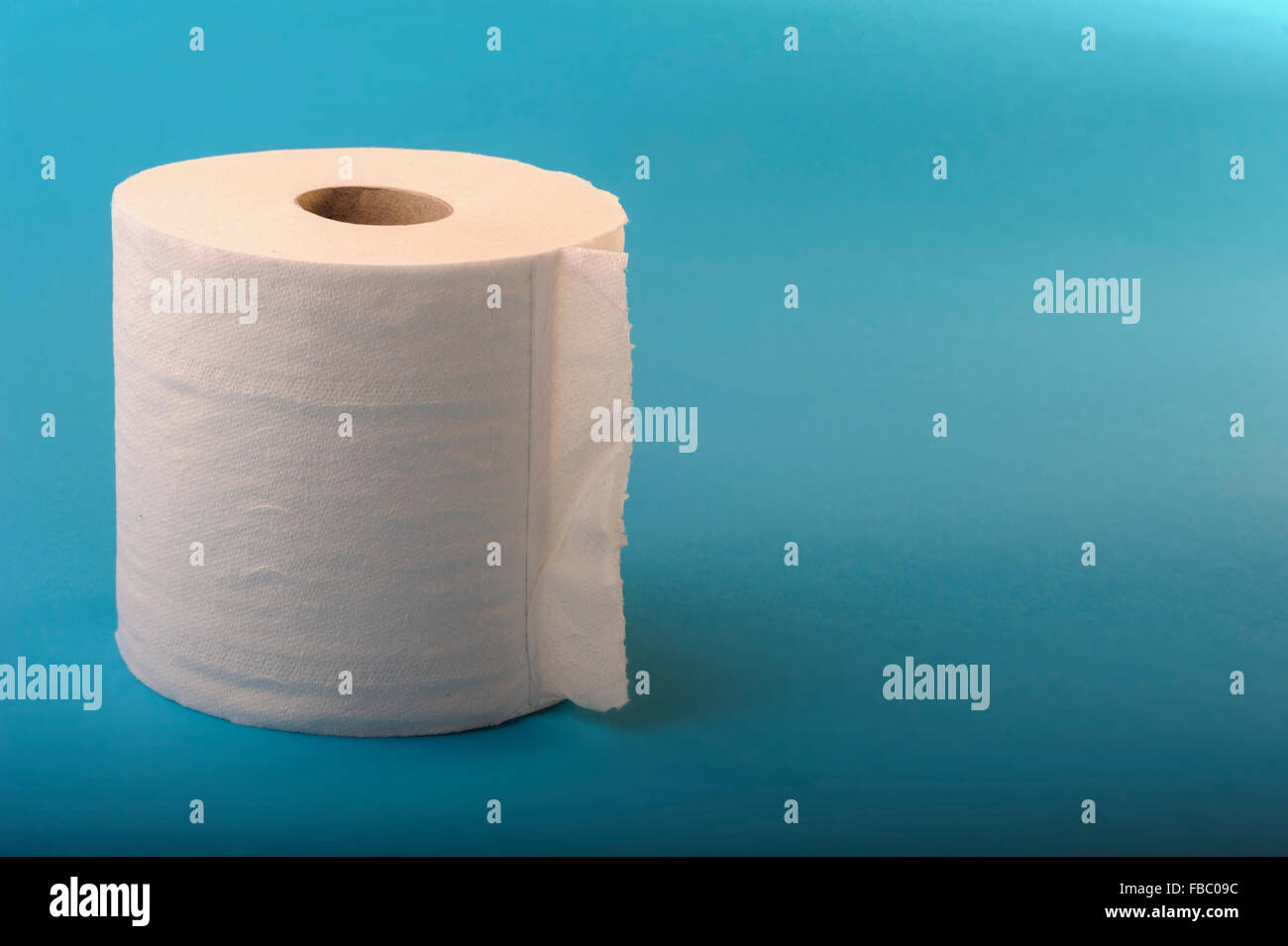 Einzelne Rolle Toilettenpapier auf blauem Grund. Stockfoto