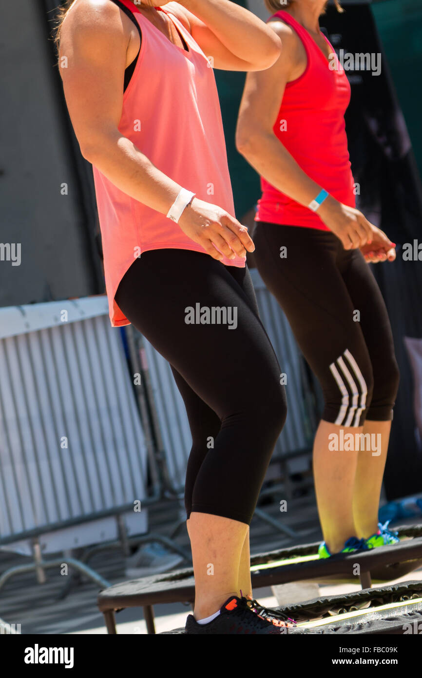 Zwei hübsche Mädchen mit rosa und roten Sportswear mit Übung auf Rebounder Stockfoto