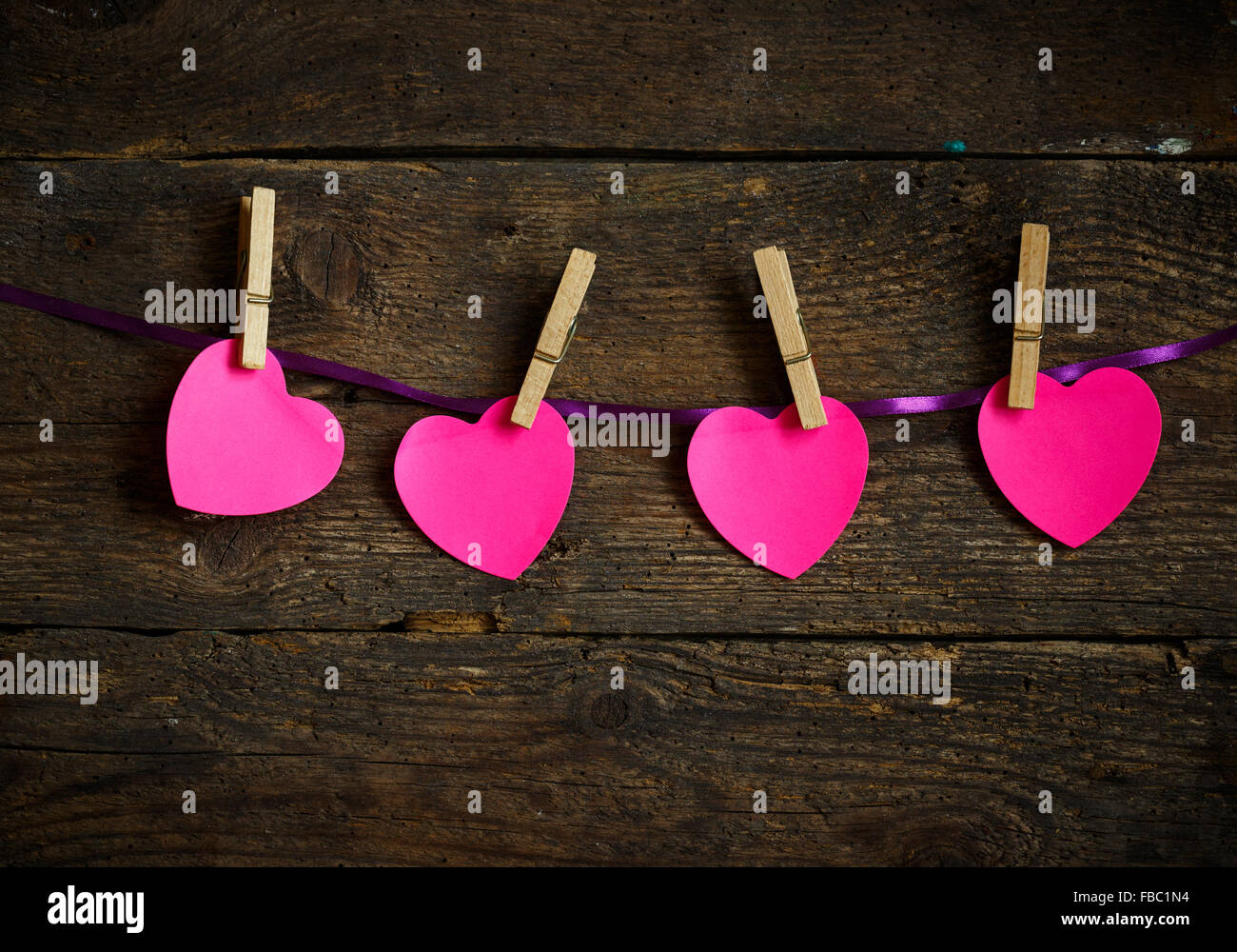 Rosa Herz Papier ausgeschnitten mit Kleidern Stifte. Bild der Valentinstag Saison. Stockfoto