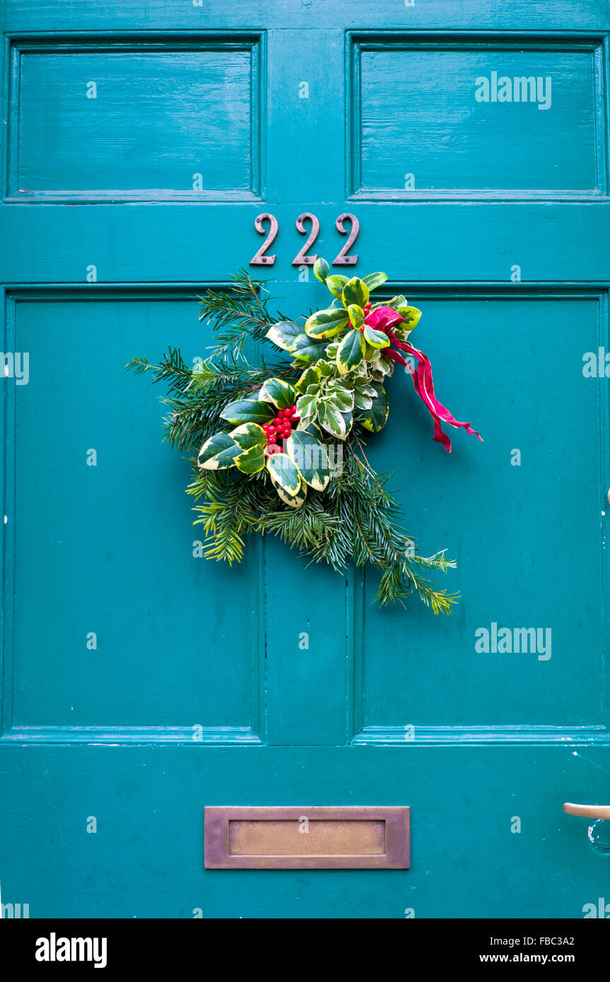 Weihnachtskranz an der Haustür aufhängen Stockfoto