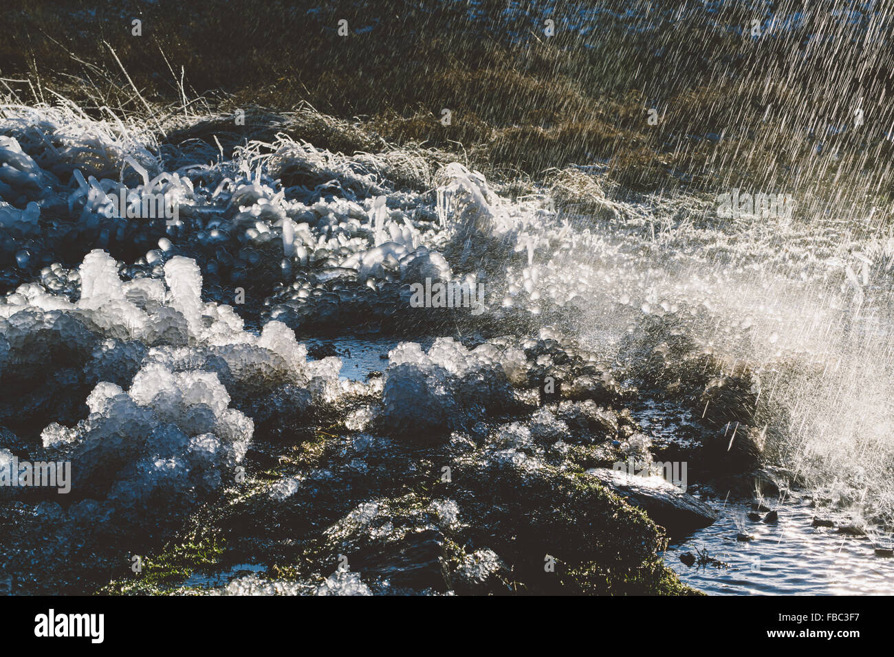 Rasen in einer erstaunlichen Form mit Wasserplätschern vereist. Stockfoto