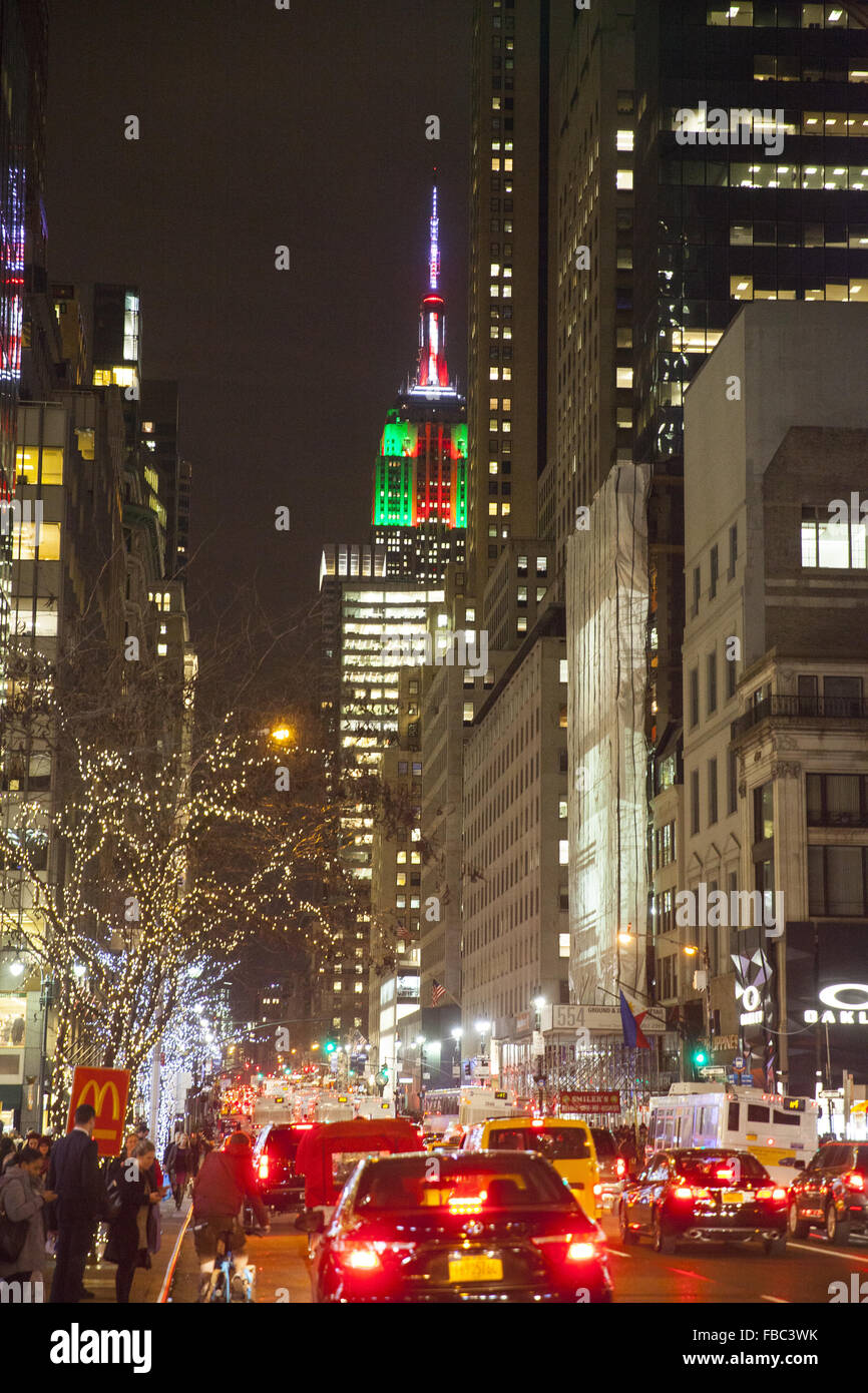 Menschen drängen sich 5th Avenue am Abend in der Weihnachtszeit mit dem Empire State Gebäude beleuchtet bis zum Süden. Stockfoto
