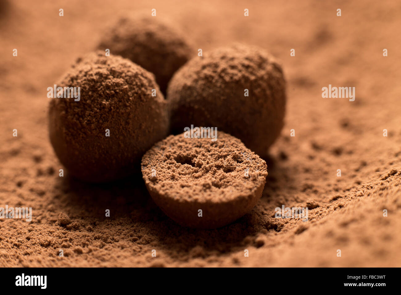 Stapel von dunkler Schokolade Trüffel. Nahaufnahme von hausgemachten Bonbons in Kakaopulver. Geringe Schärfentiefe Stockfoto