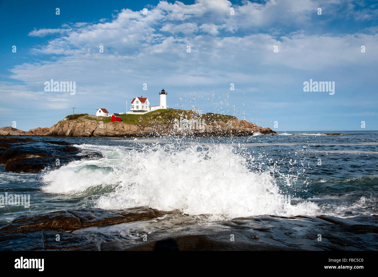Wellen auf die Felsen durch neue Produkte in Maine. Die Wellen scheinen eindeutig zu den Wolken über den Beacon widerspiegeln. Stockfoto
