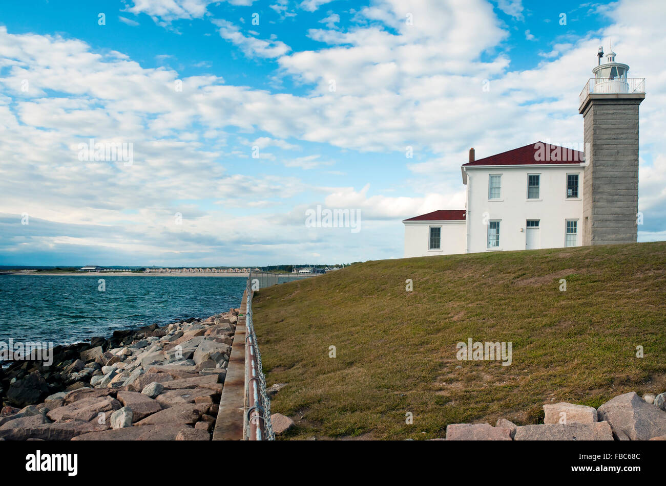 Watch Hill Leuchtturm Reiseführer Seefahrer entlang der felsigen Küste in Rhode Island. Es ist von einem Stein Seawall und felsigen Wellenbrecher geschützt. Stockfoto