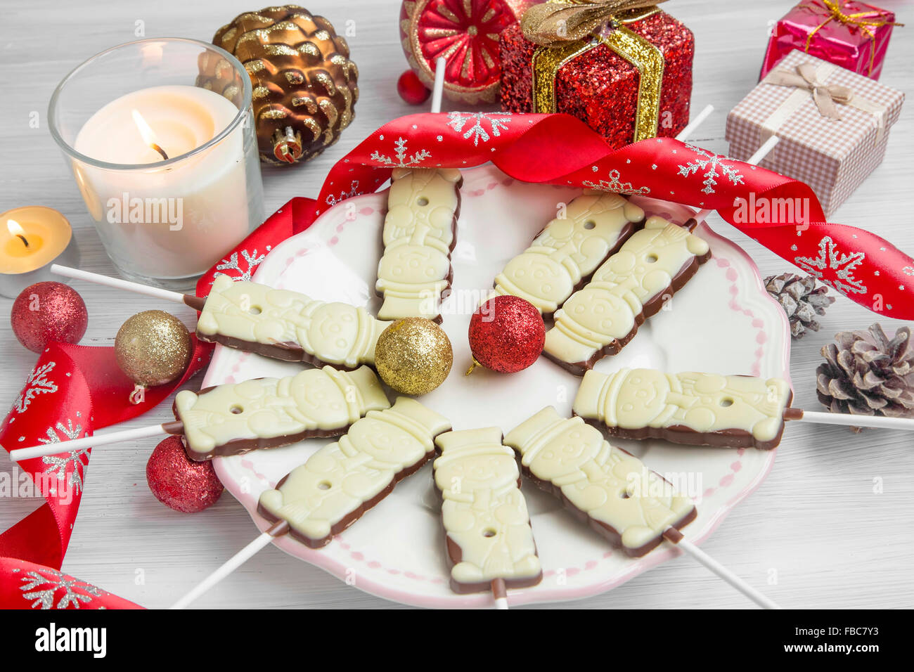 Weihnachten Schokolade Lutscher Leckereien mit festlichen Band, Duft Kerze, Geschenke und Kugeln Stockfoto