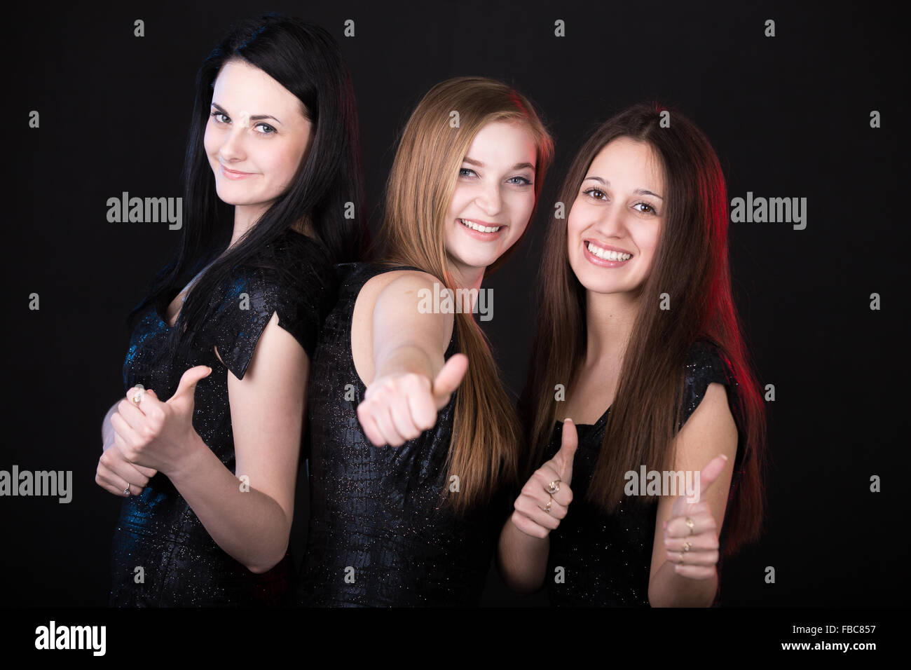 Beste Freunde glücklich lächelnd zeigt Daumen hoch, schöne Mädchen Gruppenporträt, genießen ihre Zeit Stockfoto