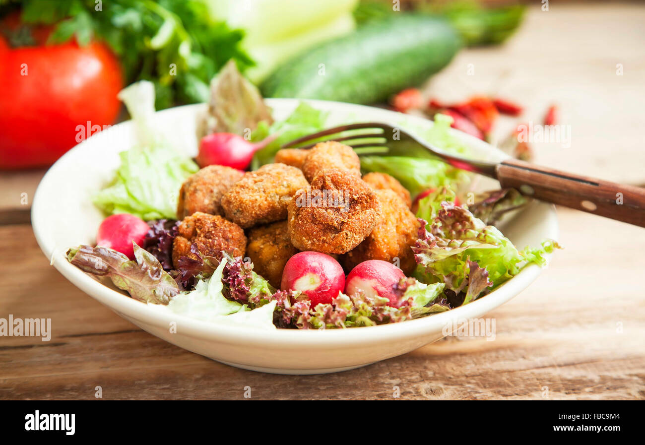 Frisch gebratenes Huhn Frikadellen mit Salat, Radieschen und Gemüse in eine Schüssel geben Stockfoto