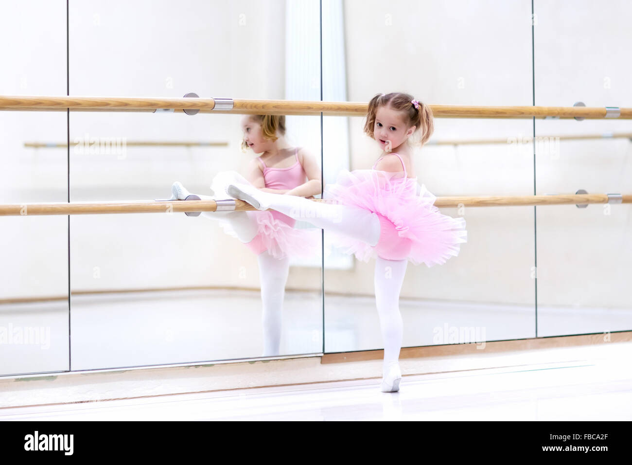 Ballerina-Mädchen in einem rosa Tutu. Entzückenden Kind Tanzen Ballett in einem weißen Studio. Kinder tanzen. Stockfoto