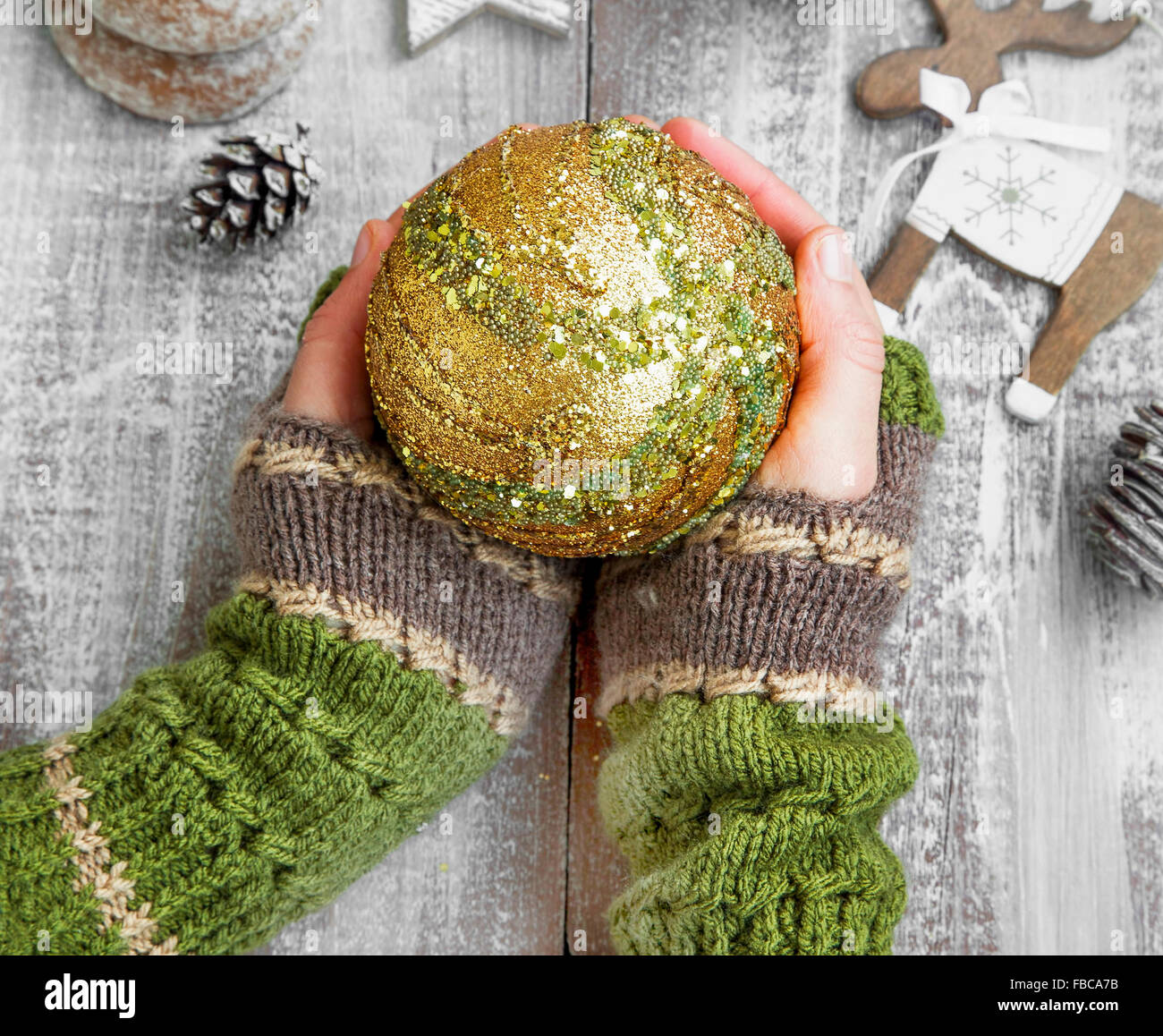 Weibliche Hände halten Weihnachten Kugel Ornament mit Glitzer und Glanz Stockfoto