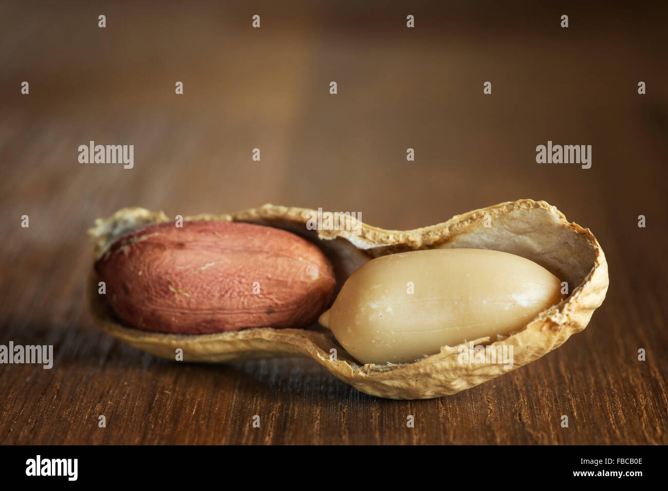 Erdnüsse geschält und ungeschält auf einem Holztisch Stockfoto