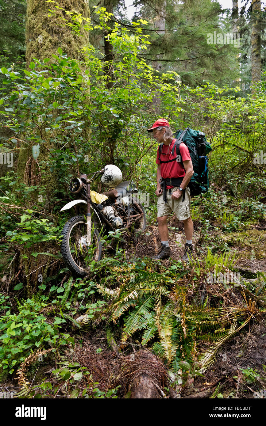 BRITISH COLUMBIA - Wanderer ein sehr altes Motorrad verlassen im Wald entlang der West Coast Trail südlich von Pachena Bay zu studieren Stockfoto