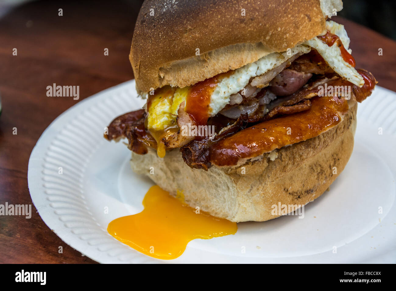 Eine gefüllte Belfast Bap mit Würstchen, Speck und Ei serviert in der traditionellen St. Georgs-Markt. Stockfoto