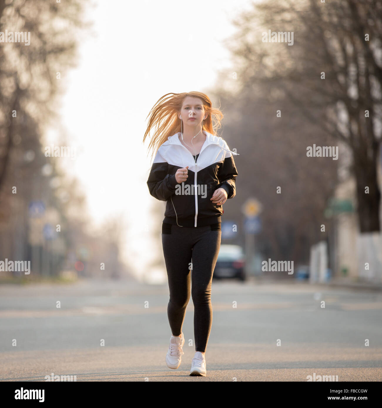 Schöne sportliche Mädchen tragen Läufer Sportbekleidung im Ohrhörer in das Morgen-Straße, gesunden, aktiven Lebensstil-Konzept Stockfoto