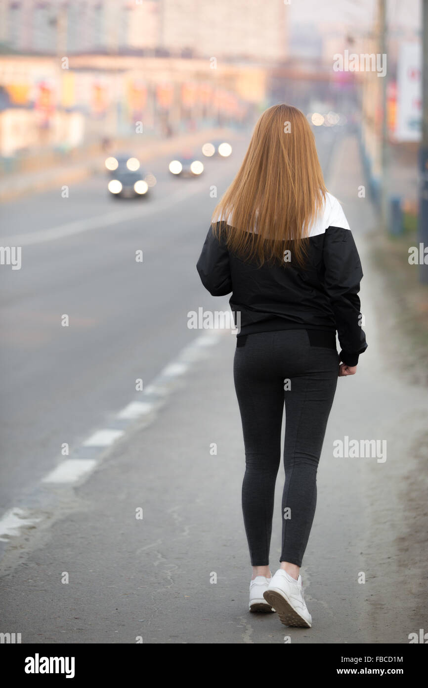 Schöne sportliche Mädchen mit langen Haaren tragen Läufer Sportbekleidung zu Fuß auf der Stadtbrücke, gesunden, aktiven Lebensstil-Konzept, ba Stockfoto