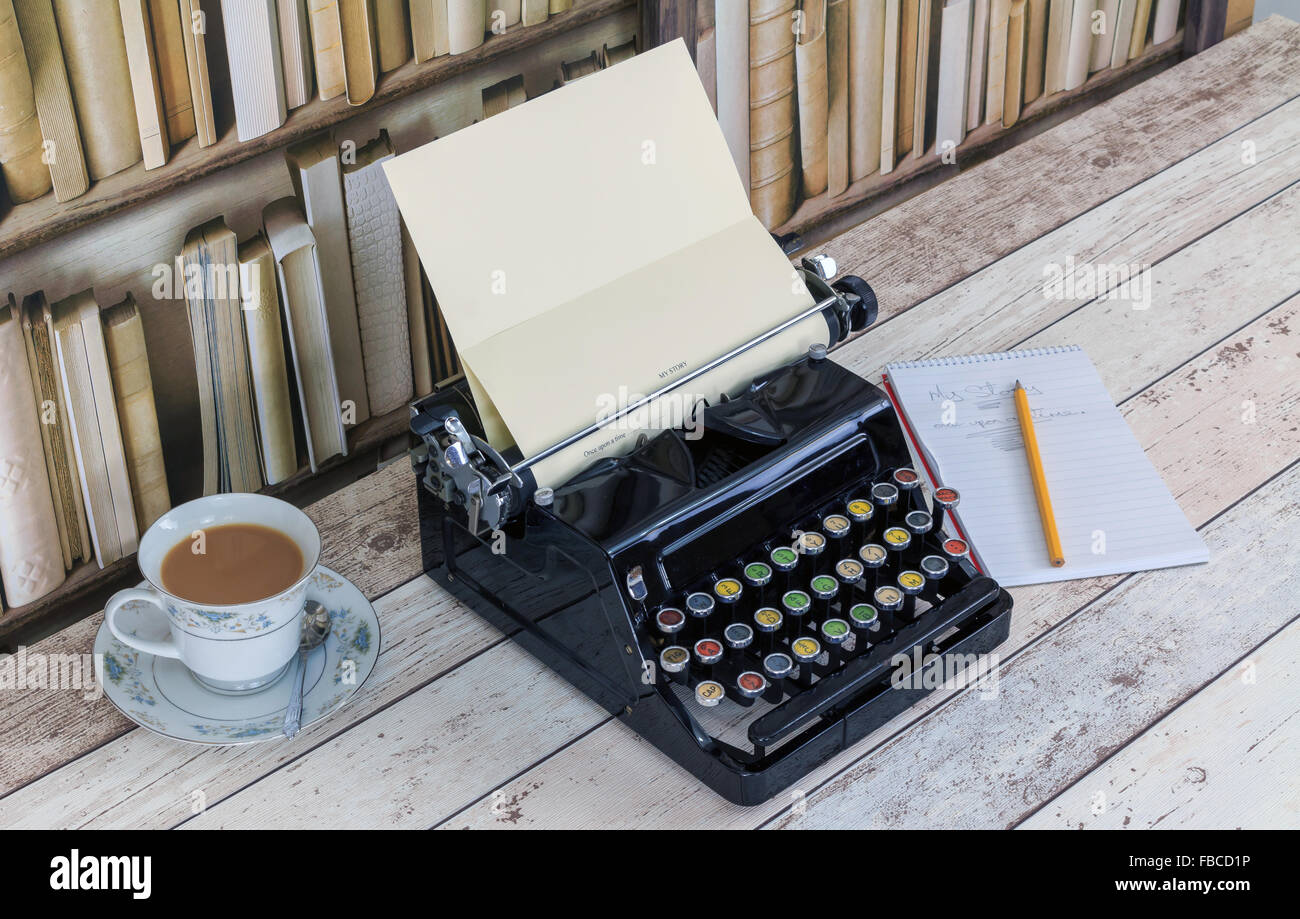 Vintage China, Schreibmaschine, Notizblock und Bleistift Teetasse mit Tee auf alten schäbigen Holzeffekt Desktop mit alten Bücherschrank Hintergrund Stockfoto