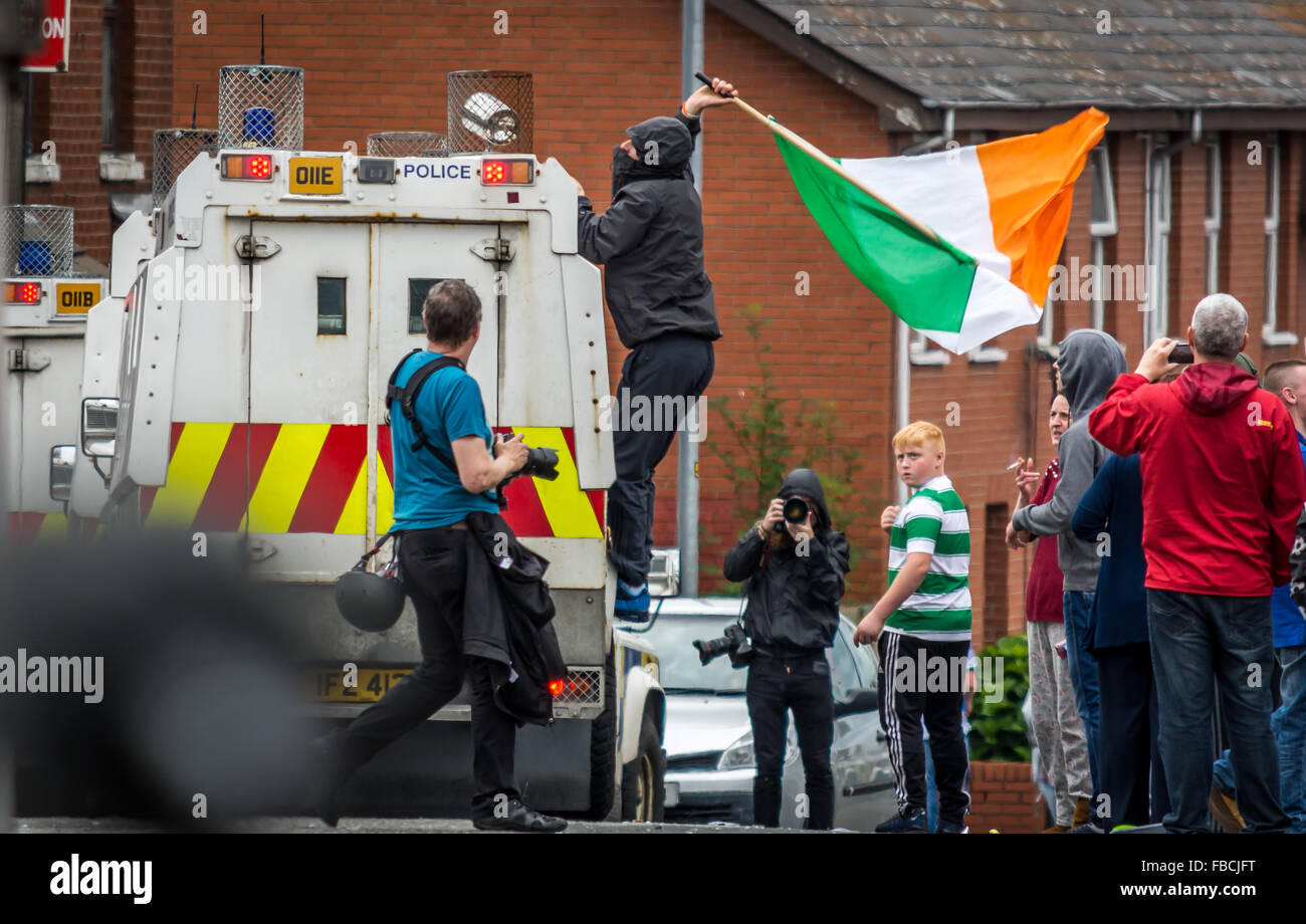 Irish Republican Demonstrant setzt eine irische Trikolore auf PSNI Land Rover in Belfast. Stockfoto