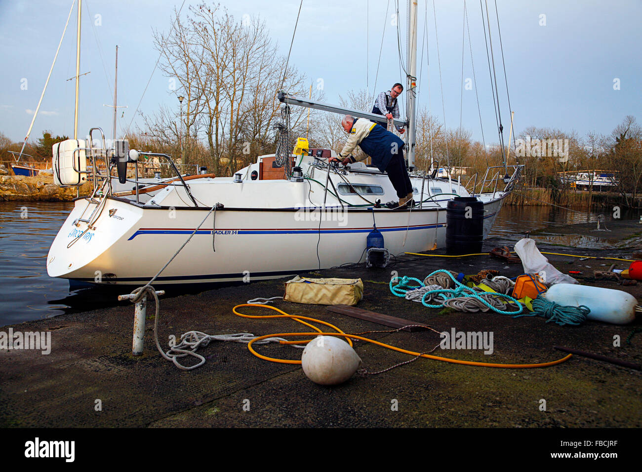 Zwei Männer bereiten auf n Lough Derg Tipperary Ireland eine 34 Fuß Saddler-Yacht für die Segelsaison vor Stockfoto