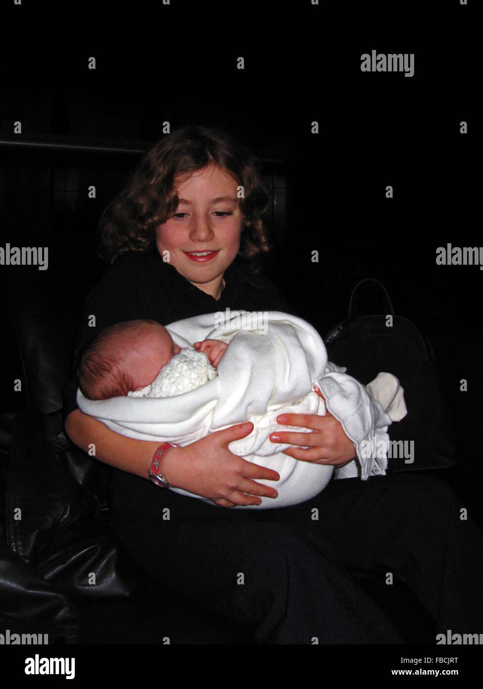 Junges Mädchen mit ihrem Säugling Cousin bei ihrer Taufe in Irland Stockfoto